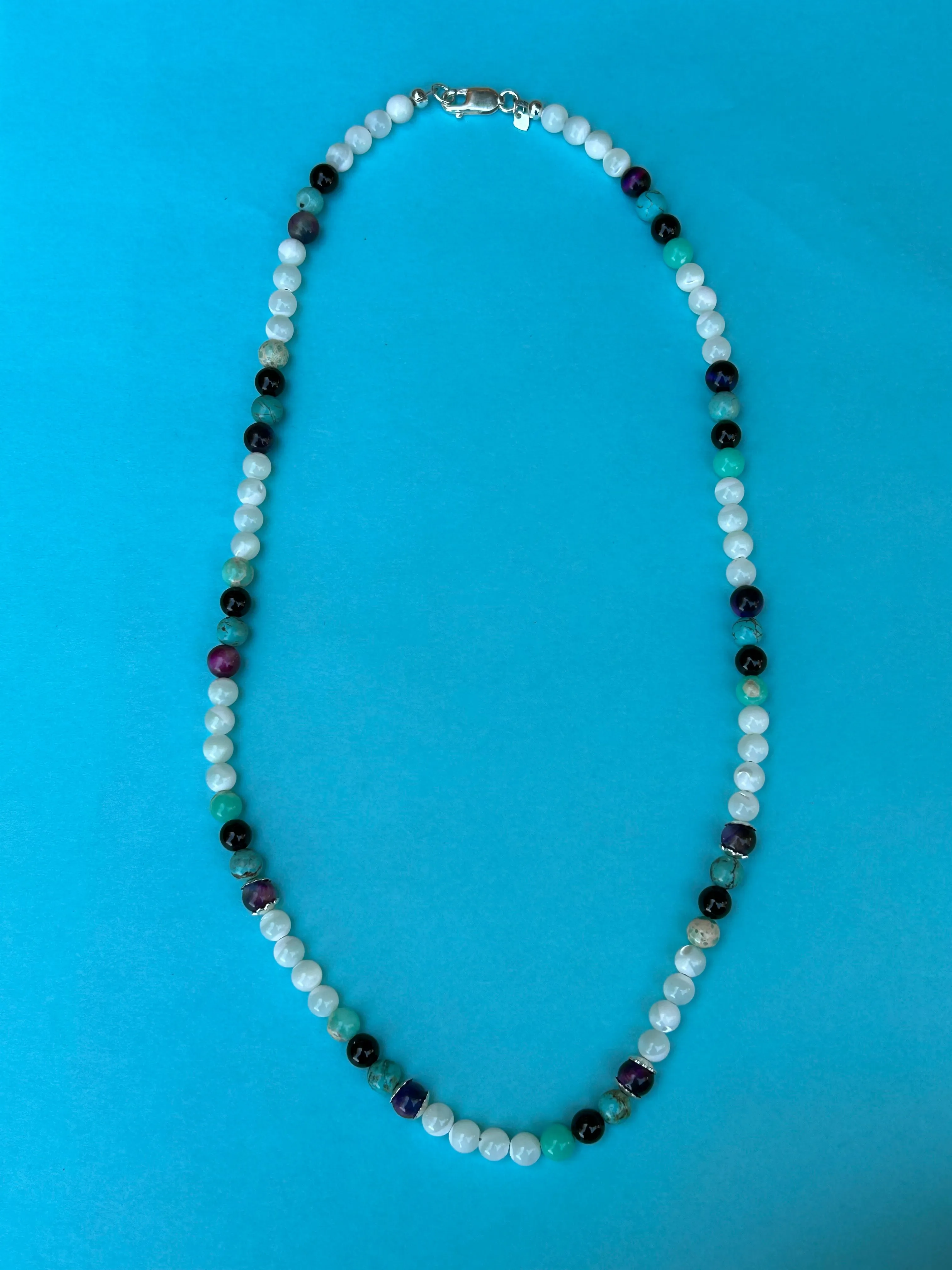 Genuine Mother of Pearl, black onyx, purple tiger eye, and sea sediment Jasper stones in a 20” necklace.  AS704